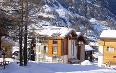 Casa-D'Amore-Zermatt-Winter-exterior-view-from-far-with-snow-and-trees