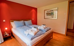 Apartment-Matthew-Zermatt-Bedroom-with-view-inside-bed-picture-on-the-wall-red-wall