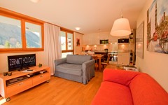 Casa-D'Amore-Zermatt-Living-area-with-view-on-kitchen-area-sofa-and-tv