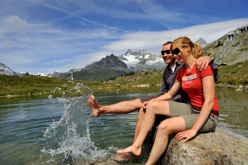Ein Paar geniesst die Abkühlung am Leisee Zermatt